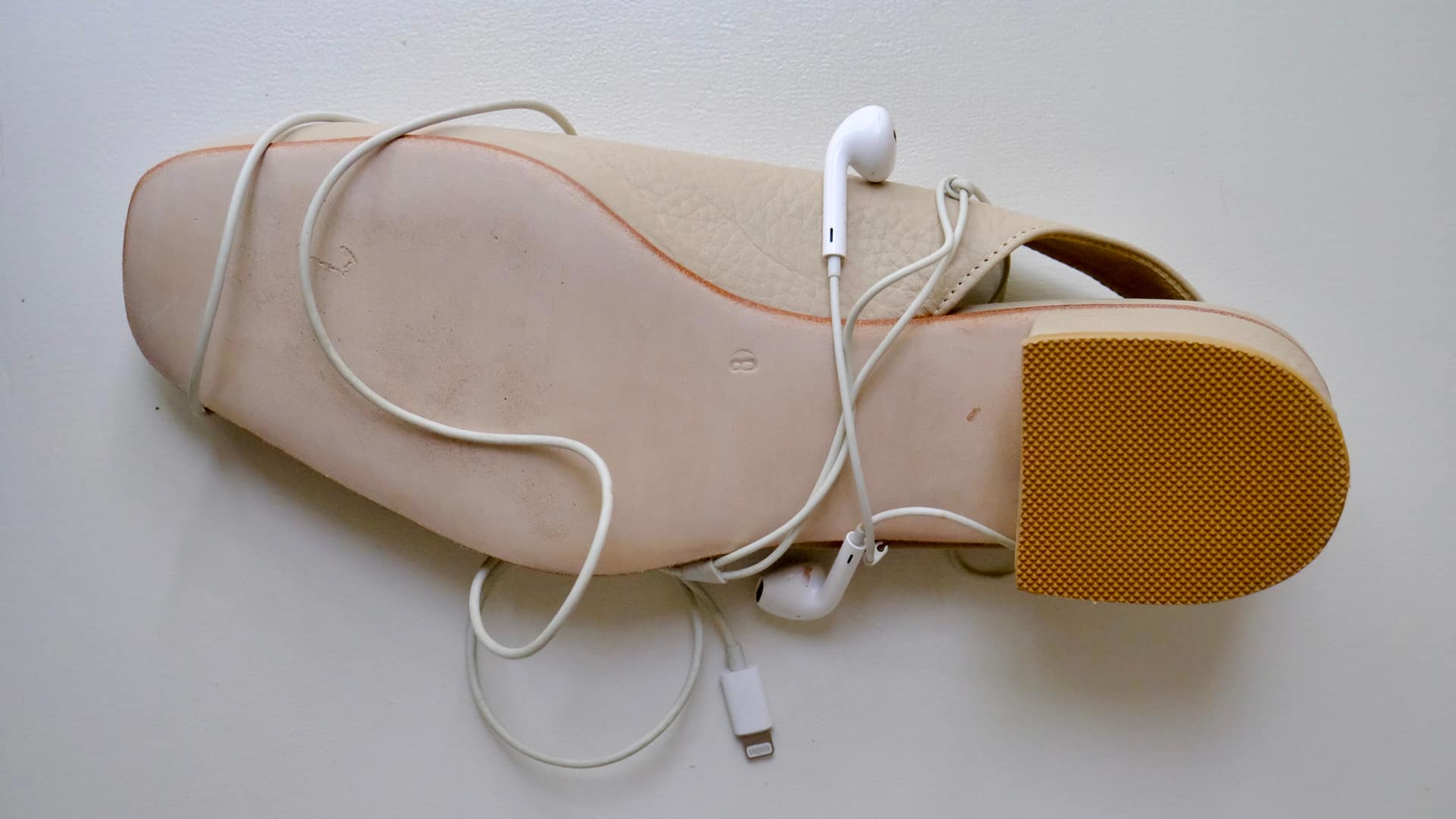 Zapato crema con auriculares, still life